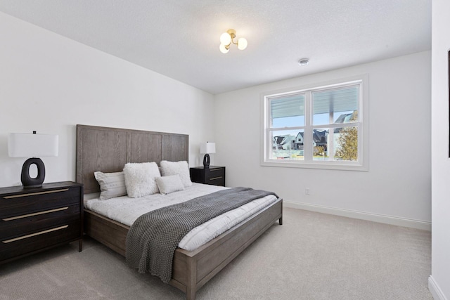 bedroom with light carpet and baseboards