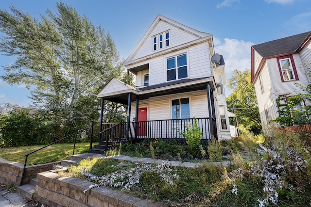 american foursquare style home featuring covered porch