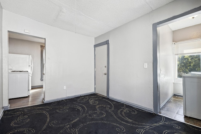 unfurnished room featuring baseboards and a textured ceiling