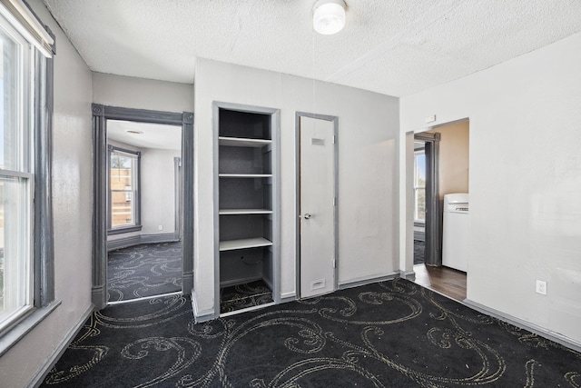 unfurnished bedroom featuring a textured ceiling and baseboards