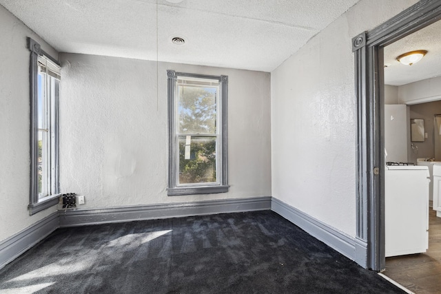 spare room featuring visible vents, a textured ceiling, and a textured wall