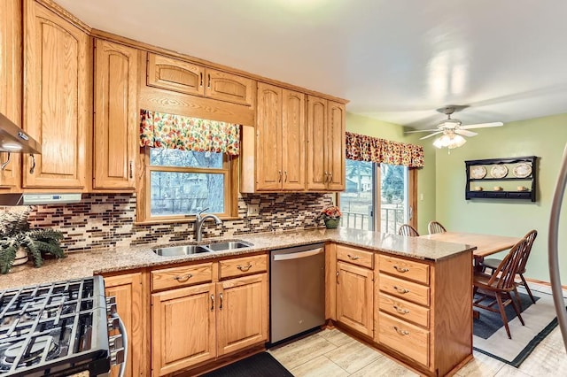 kitchen featuring tasteful backsplash, dishwasher, a peninsula, and a sink