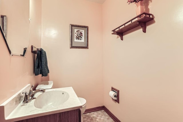 bathroom with toilet, tile patterned floors, baseboards, and vanity