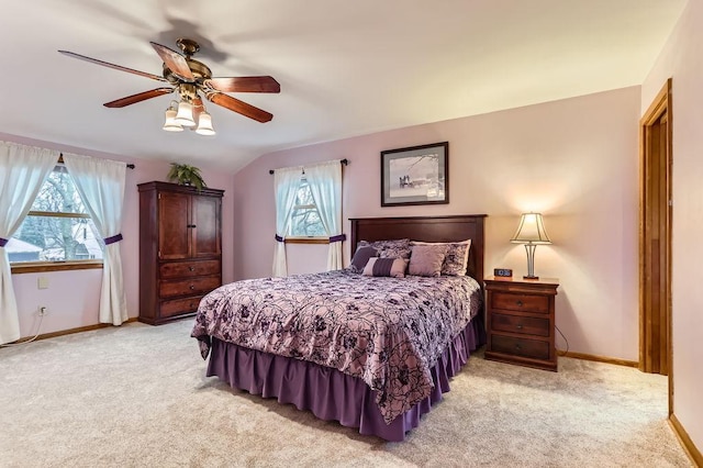 bedroom with a ceiling fan, lofted ceiling, light colored carpet, and baseboards