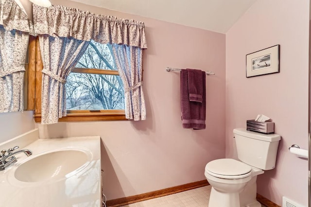 half bath with visible vents, vanity, toilet, and baseboards