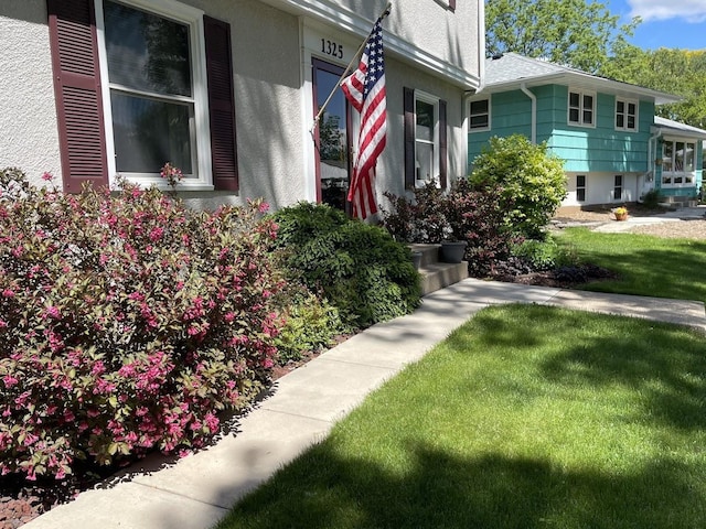 exterior space featuring a lawn and stucco siding