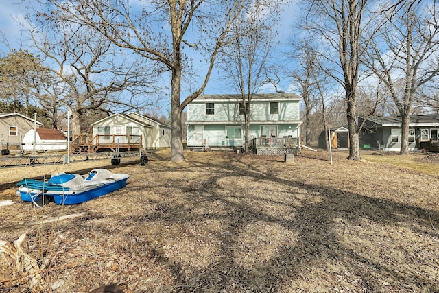 rear view of property with a deck and a shingled roof