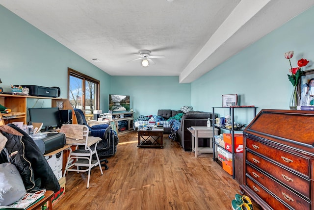 living area featuring visible vents, ceiling fan, and wood finished floors