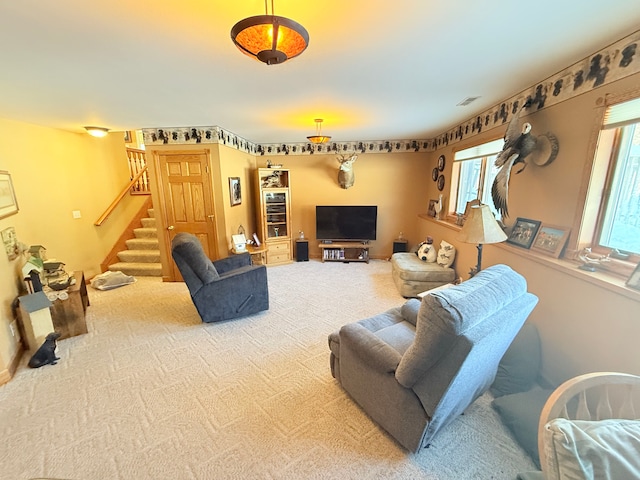 carpeted living room featuring visible vents and stairs