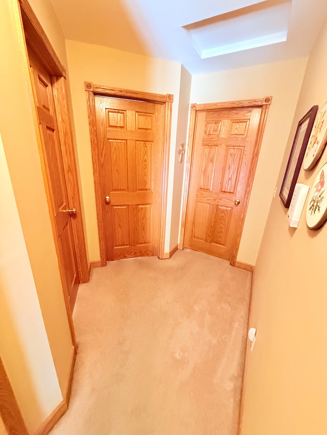 hallway featuring carpet flooring and baseboards