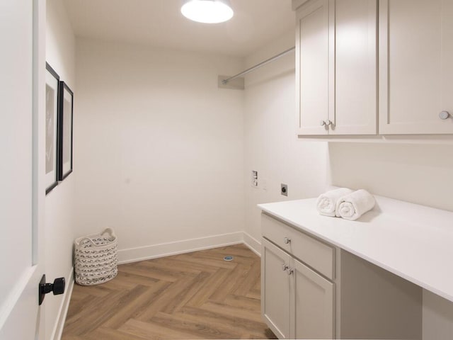 laundry room with cabinet space, baseboards, and electric dryer hookup