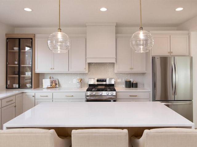 kitchen featuring premium range hood, appliances with stainless steel finishes, a kitchen breakfast bar, and decorative backsplash