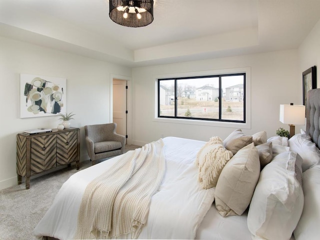 bedroom featuring carpet floors, baseboards, and a raised ceiling