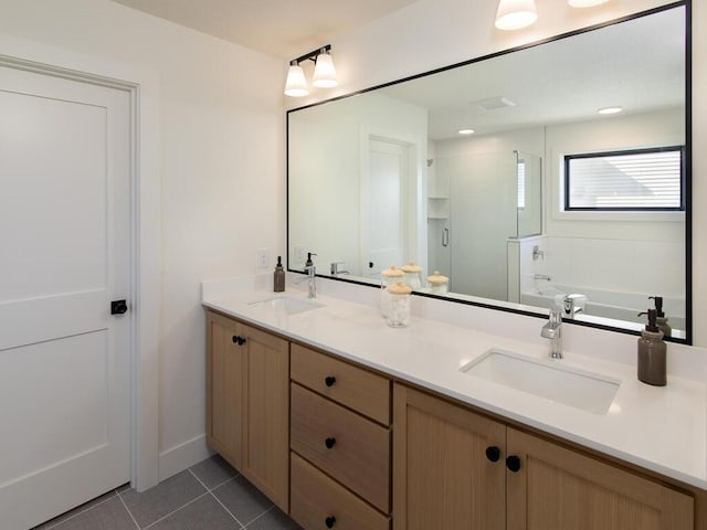 bathroom with double vanity, a stall shower, a sink, and tile patterned floors