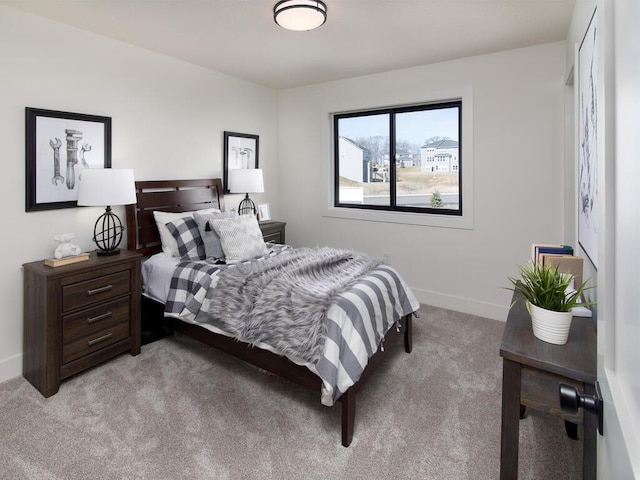 bedroom featuring light carpet and baseboards