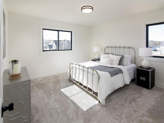 carpeted bedroom with visible vents and baseboards