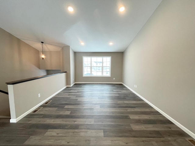 unfurnished living room with dark wood-style floors, recessed lighting, and baseboards