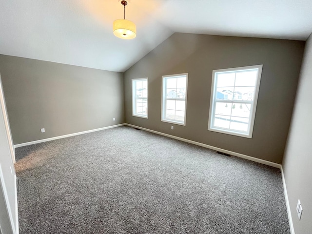 carpeted empty room with lofted ceiling, visible vents, and baseboards