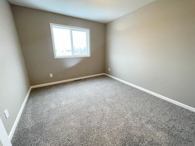 carpeted spare room with baseboards