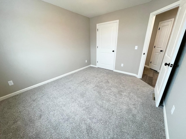 unfurnished bedroom featuring carpet flooring and baseboards