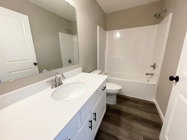 bathroom with toilet,  shower combination, wood finished floors, and vanity