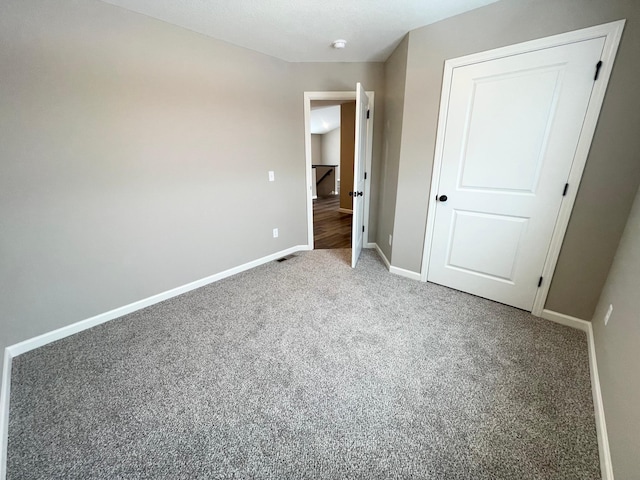 unfurnished bedroom featuring light carpet and baseboards