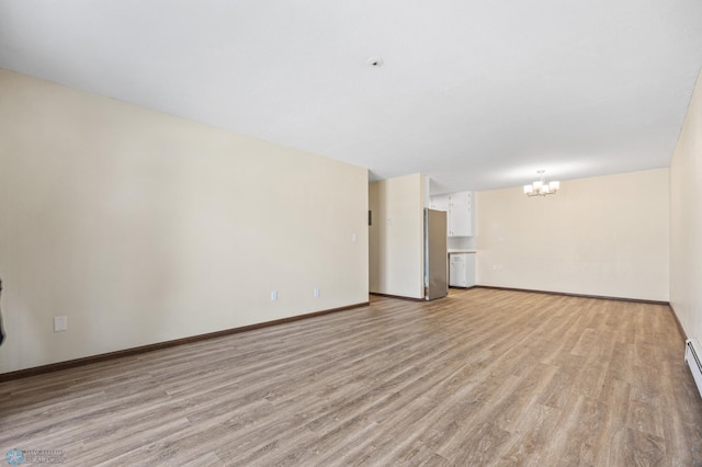 unfurnished living room featuring baseboards, a notable chandelier, baseboard heating, and light wood finished floors