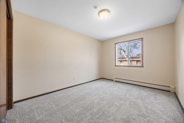 empty room featuring a baseboard radiator, carpet floors, and baseboards