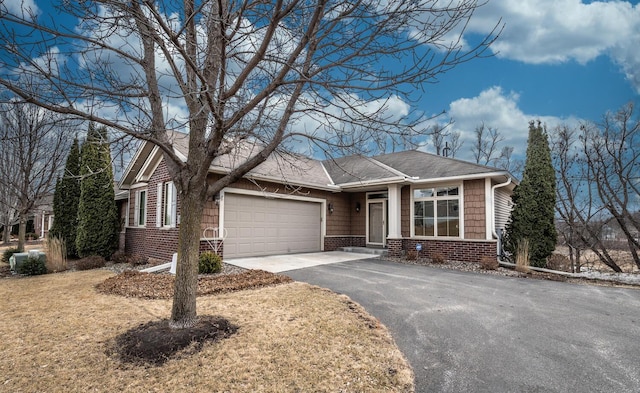 view of front of house with a garage, brick siding, and driveway