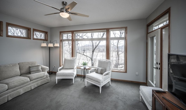 living area featuring carpet, ceiling fan, a textured ceiling, and baseboards