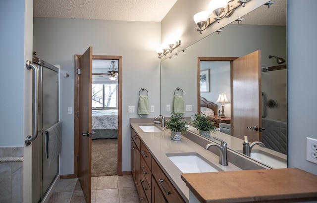 ensuite bathroom featuring a sink, a textured ceiling, ensuite bath, and tile patterned floors