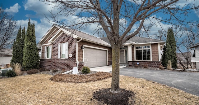 single story home featuring a garage, driveway, and brick siding