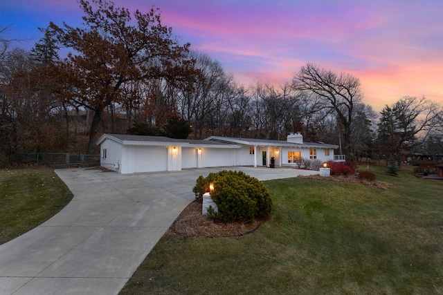 view of front of home with driveway, a front lawn, a chimney, and fence