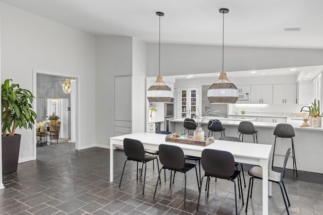 dining room with high vaulted ceiling, recessed lighting, and baseboards