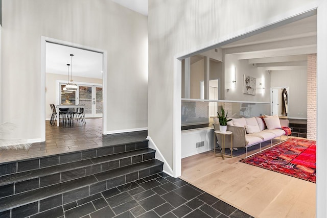 interior space featuring dark wood-type flooring, baseboards, visible vents, and a high ceiling