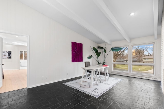 unfurnished dining area with recessed lighting, stone finish flooring, beamed ceiling, and baseboards