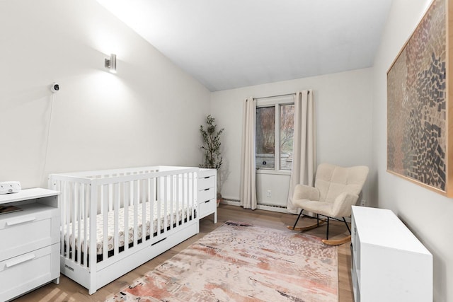 bedroom featuring a crib and wood finished floors