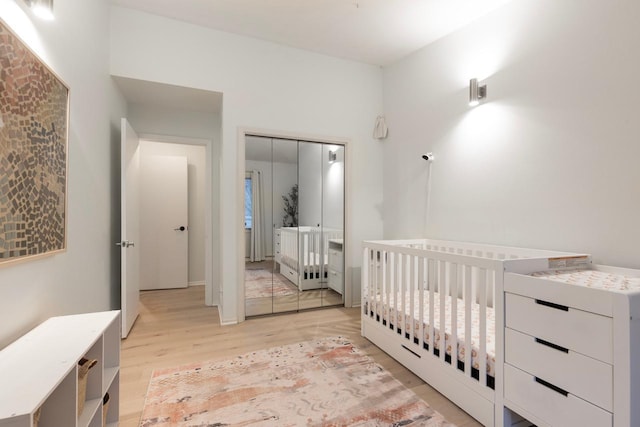 bedroom with light wood-type flooring and a closet