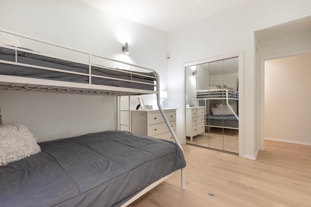 bedroom featuring a closet, baseboards, and wood finished floors