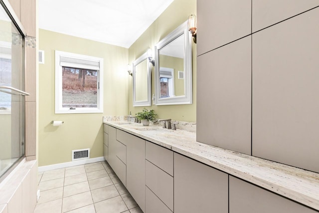 bathroom featuring double vanity, visible vents, tile patterned flooring, an enclosed shower, and a sink