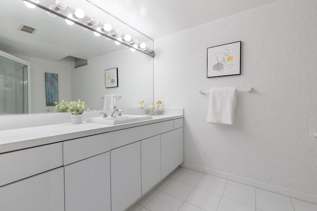 full bathroom featuring a textured wall, vanity, visible vents, and a shower stall