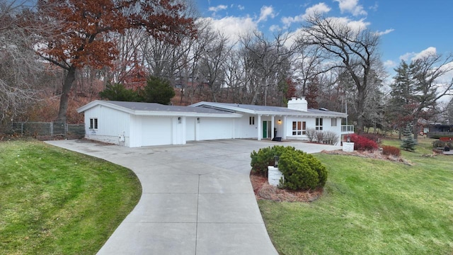 ranch-style home featuring a garage, driveway, a chimney, fence, and a front lawn