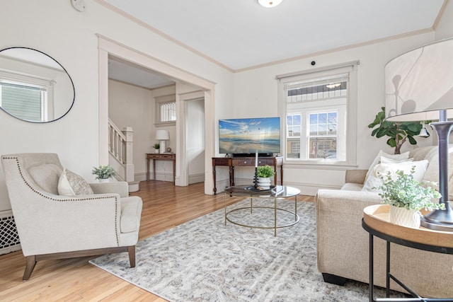 living room with stairs, baseboards, wood finished floors, and crown molding