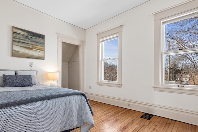 bedroom with visible vents, baseboards, and light wood-style floors