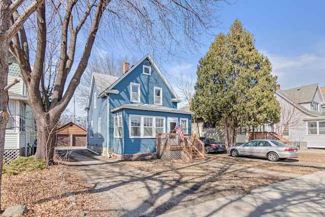 view of front of home with a detached garage and a chimney