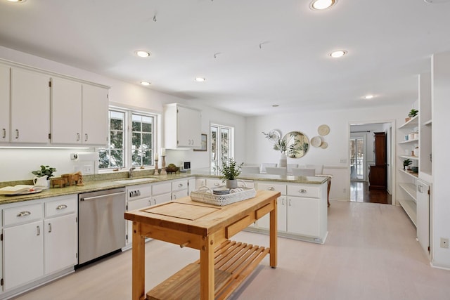 kitchen with stainless steel dishwasher, a peninsula, recessed lighting, and white cabinetry