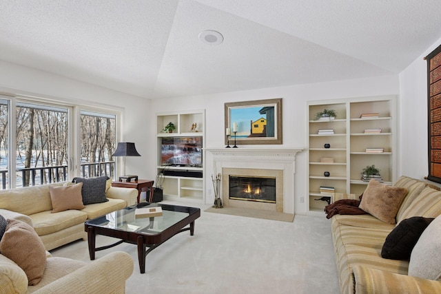 living area featuring built in features, a fireplace with flush hearth, a textured ceiling, and carpet flooring