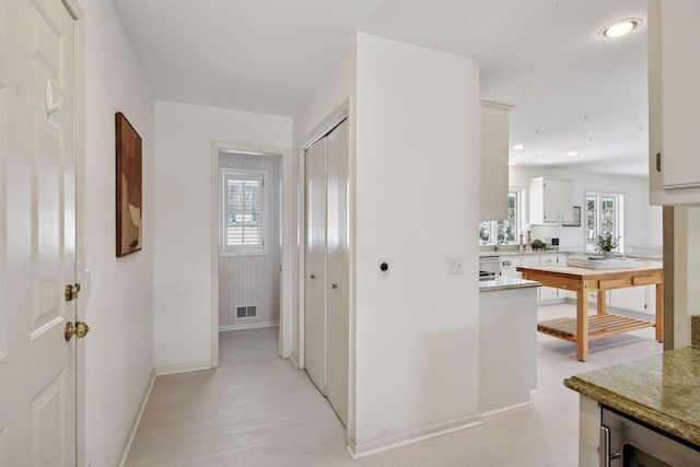 hallway with wine cooler, visible vents, recessed lighting, and baseboards