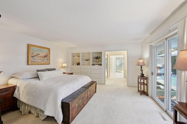 bedroom with access to outside, light colored carpet, visible vents, and a textured ceiling