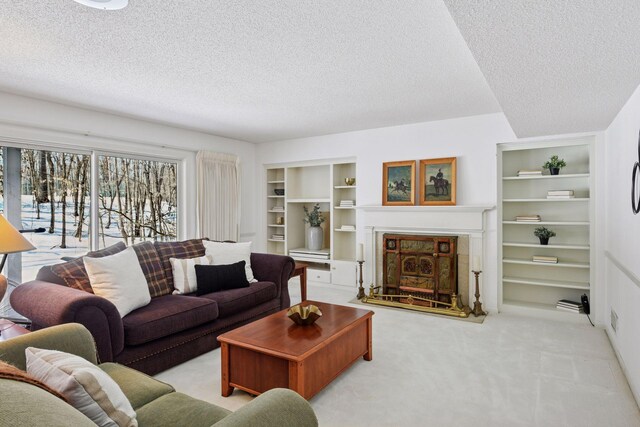 living room with built in features, carpet floors, a textured ceiling, and a fireplace